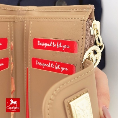 Carteira bege em couro sintético com detalhes dourados e cartões vermelhos com texto