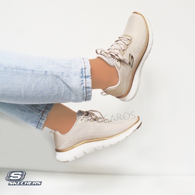 Sapatilhas Skechers bege com detalhes dourados e sola branca usadas com calças de ganga