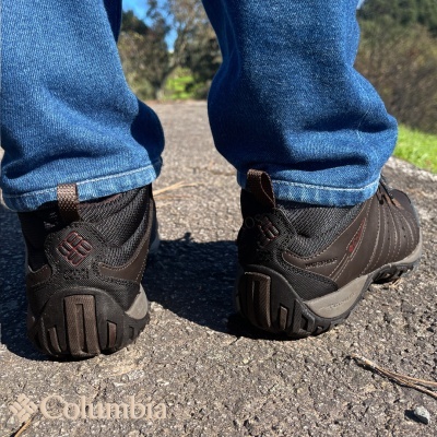 Tênis de caminhada pretos com calças azuis em estrada asfaltada
