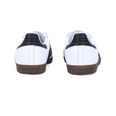 Sapatilhas brancas e pretas vistas de trás com sola castanha