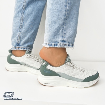 Ténis SKECHERS SLIP-INS em branco e verde-acinzentado com sola branca usados com jeans claros