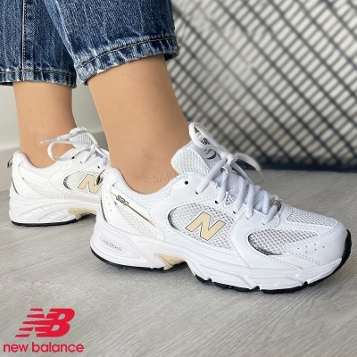 Ténis New Balance brancos com detalhes dourados e sola preta