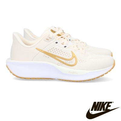 Sapatilhas Nike de corrida creme com detalhes dourados e sola branca.