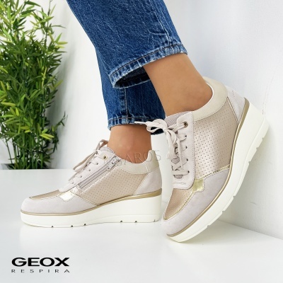 Sapatilhas Geox bege com detalhes dourados e sola branca em ambiente minimalista