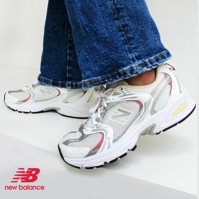 Ténis New Balance brancos com detalhes coloridos usados com calças de ganga