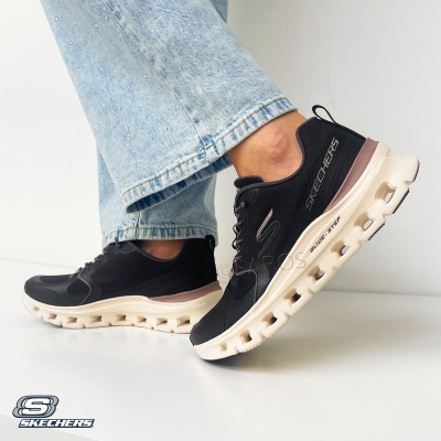 Sapatilhas pretas Skechers com sola creme usadas com calças de ganga claras