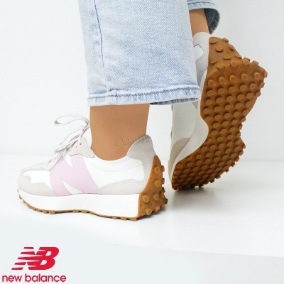 Ténis New Balance brancos e rosa com sola castanha em fundo branco
