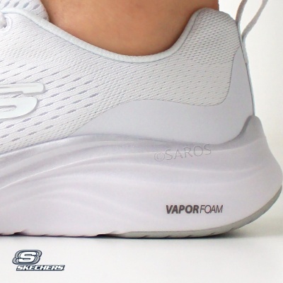 Tênis branco Skechers com sola Vapor Foam usado num pé
