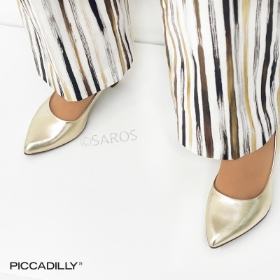 Sapatos de salto dourado e calças listradas com padrão vertical