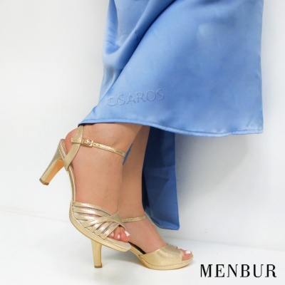 Sandálias de salto médio douradas com tiras finas e saia azul clara