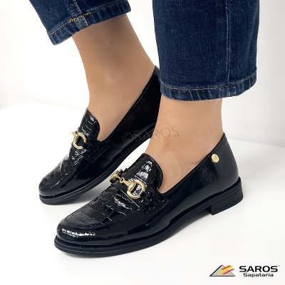 Sapatos mocassins pretos em verniz com padrão crocodilo e detalhe metálico dourado.