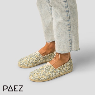 Sapatos alpercata coloridos com padrão abstrato e calças de ganga claras