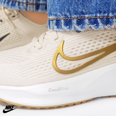 Ténis Nike de corrida bege com logótipo dourado e sola branca