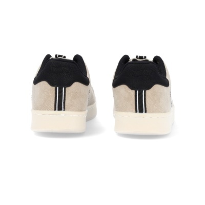 Par de ténis bege e pretos vistos de trás