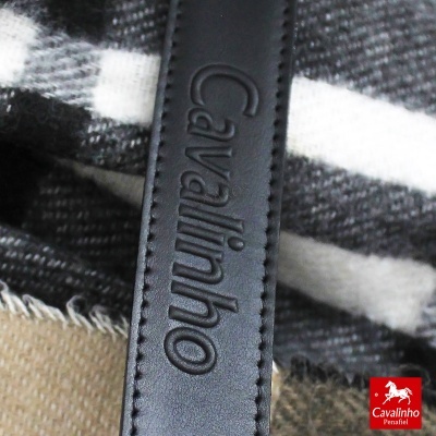Tira de pele preta com costura e texto Cavalinho sobre tecido xadrez cinza e branco.