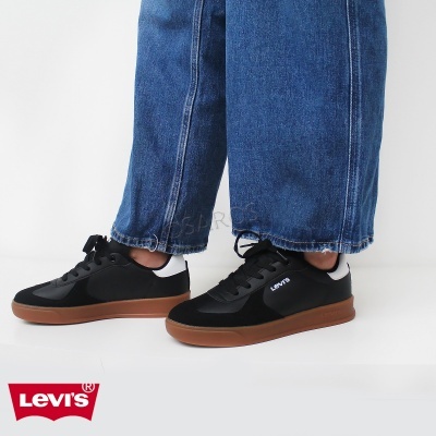 Ténis Levi's pretos com sola castanha e detalhe branco no calcanhar, usados com jeans azuis