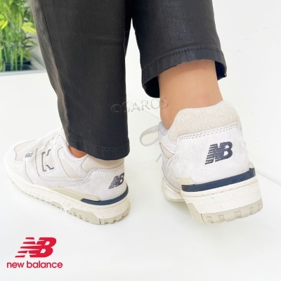 Ténis New Balance branco com detalhes cinza e logótipo preto na parte traseira.