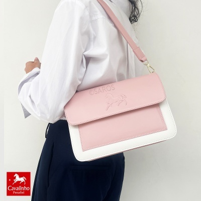 Mala bicolor rosa e branca com relevo de cavalo e texto ©SAROS