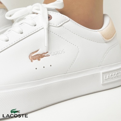Ténis brancos Lacoste com logótipo de crocodilo dourado e detalhes em bege