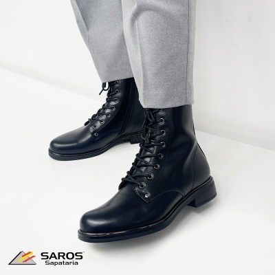 Botas pretas de cabedal com atacadores usadas com calças cinza claras