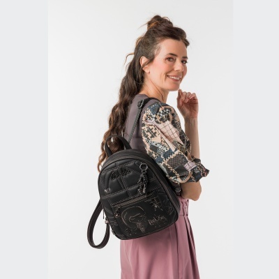 Mulher com mochila preta e roupa de padrão animal print