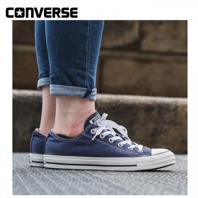 Ténis Converse azul com atacadores brancos e sola branca usados com jeans