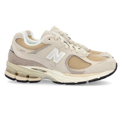 Tênis desportivo New Balance em tons bege e castanho claro com sola branca e detalhes em camurça e malha