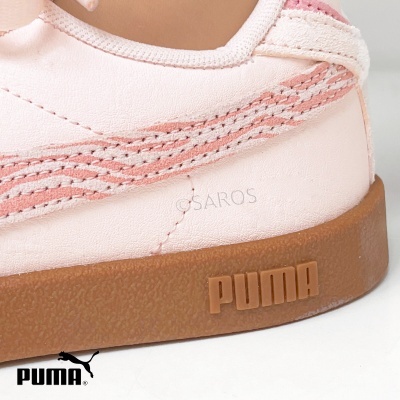 Parte lateral de um ténis rosa claro da marca Puma com sola castanha