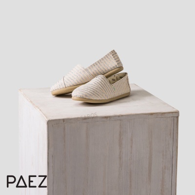 Alpercatas bege com riscas brancas sobre pedestal branco