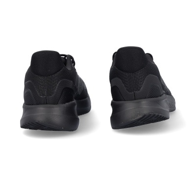 Ténis pretos de tecido com sola preta vistos de trás sobre fundo branco.