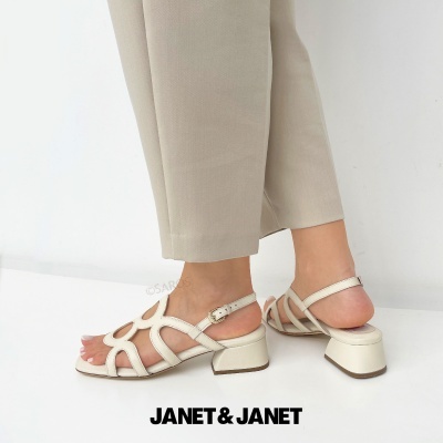 Sandálias creme com tiras e salto médio, calças bege e texto JANET & JANET