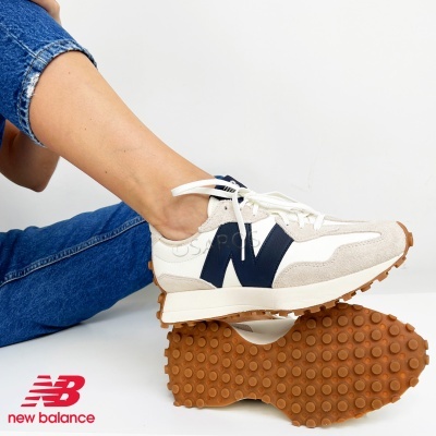 Sapatilhas New Balance brancas com detalhes azul escuro e sola castanha texturizada