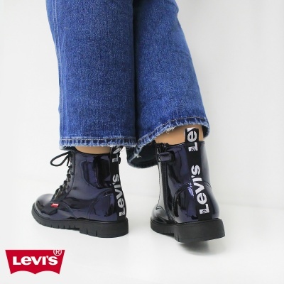 Botas pretas brilhantes com etiqueta Levi's usadas com calças de ganga azul