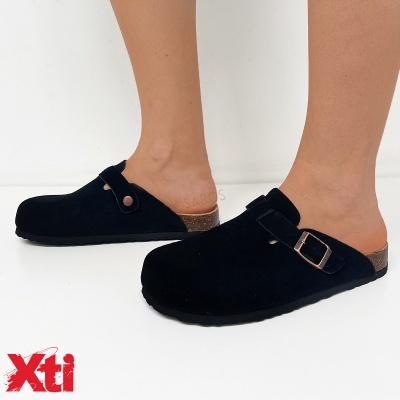 Sapatos mule pretos com fivela dourada e sola castanha em modelo