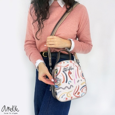 Mochila pequena com padrão abstrato colorido com alças castanhas em modelo feminino