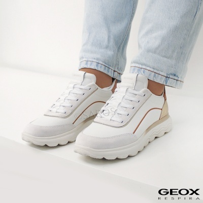 Ténis Geox brancos com detalhes castanhos e bege usados com jeans azul claro