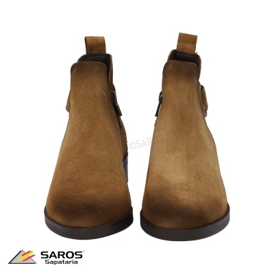 Botas chelsea castanhas em camurça com sola preta sobre fundo branco.