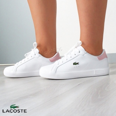 Ténis brancos Lacoste com detalhes rosa e logo verde, usados por pessoa