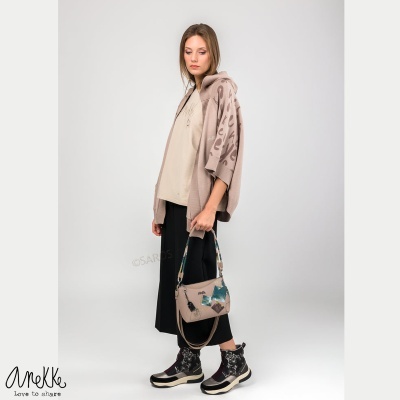 Mulher vestindo casaco bege com padrão animal print, calças pretas largas, botas e mala com padrão animal print, fundo branco