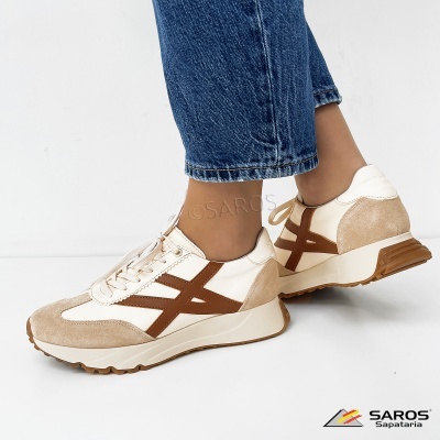 Ténis brancos e castanhos em pele e camurça com sola de borracha usados com calças de ganga azul