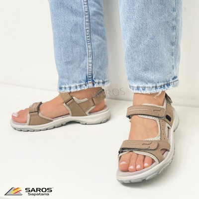 Sandálias desportivas femininas bege com fechos de velcro e sola branca usadas com calças de ganga