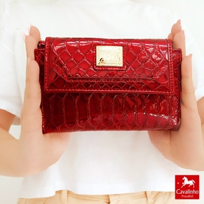 Carteira vermelha com padrão de pele de crocodilo e placa metálica dourada