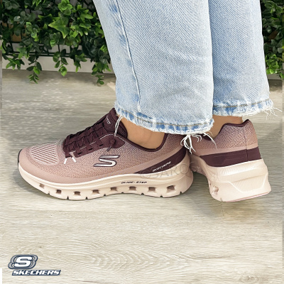Ténis Skechers rosa e vinho com sola branca usados com jeans claros e plantas ao fundo