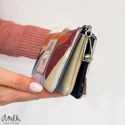 Carteira multicolorida com fecho metálico prateado e desenho de gato em couro sintético.