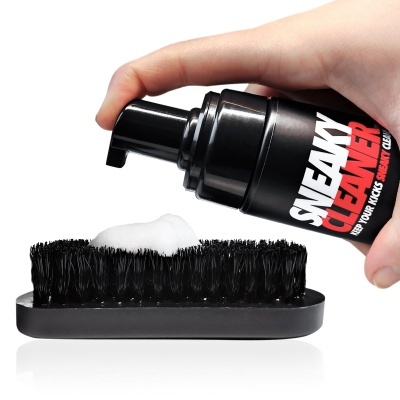 Frasco preto de produto de limpeza SNEAKY CLEANER a aplicar espuma com escova preta.