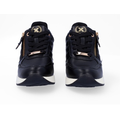 Sapatilhas pretas com detalhes dourados e sola branca vistas de frente