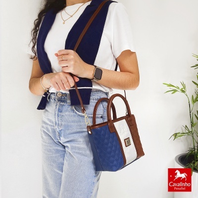 Mala de mão feminina Cavalinho azul, branco e castanho com logótipo, alça ajustável, em fundo branco.