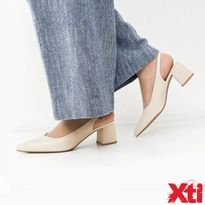 Sapatos creme de salto médio com calças de ganga azuis