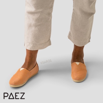 Alpargatas laranja texturizadas com sola clara e calças bege