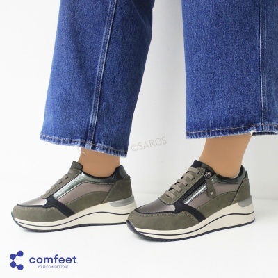 Sapatilhas verdes e cinza com sola branca usadas com calças de ganga azuis